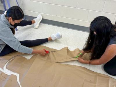 Students cut out the body they are tracing.